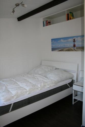 特拉弗明德Haus am Priwallstrand的灯塔间的一个白色床