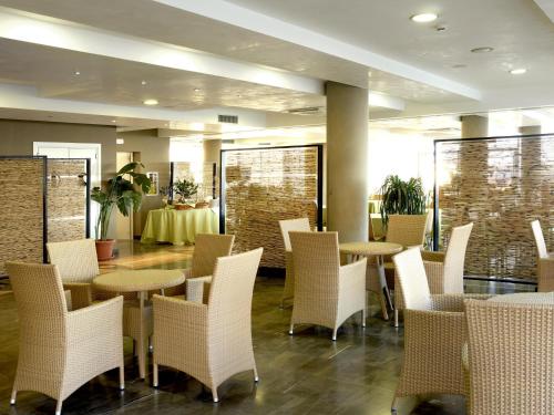 阿布鲁齐的罗塞托德玛尔公寓式酒店的一间带白色椅子和桌子的餐厅以及一间带桌子的房间