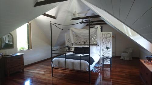 班加洛巴恩度假屋的阁楼卧室配有天蓬床