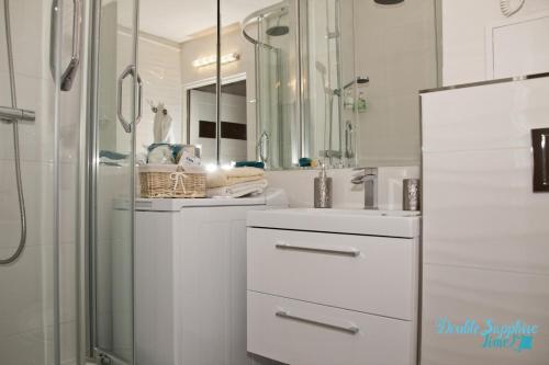 罗兹Apartment Double Sapphire Time的带淋浴和盥洗盆的白色浴室