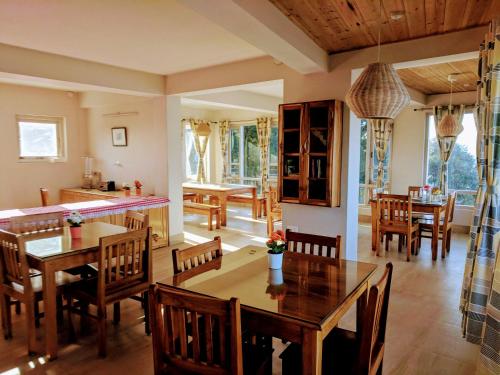 噶伦堡玉如德乐旅馆的厨房以及带木桌和椅子的用餐室。