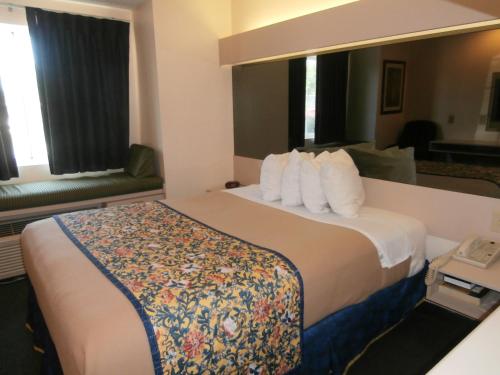 麦克多诺America's Best Value Inn & Suites-McDonough的酒店客房配有一张带白色枕头的大床