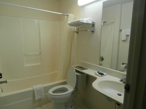 麦克多诺America's Best Value Inn & Suites-McDonough的白色的浴室设有卫生间和水槽。