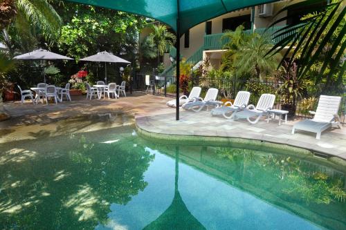 达尔文城市花园公寓 的一个带桌椅和遮阳伞的游泳池