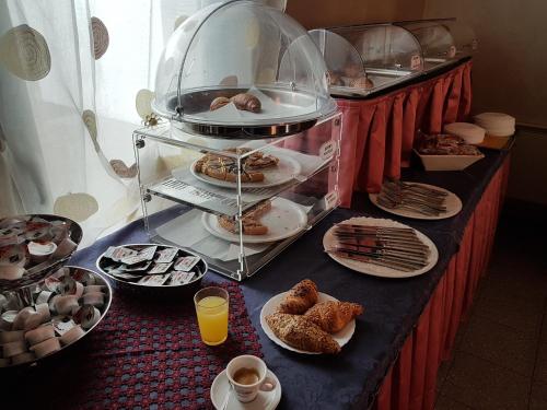 Castelvetro PiacentinoMaster Hotel的桌子上放着糕点盘和咖啡杯