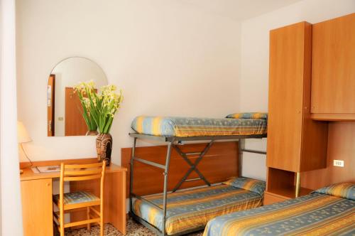 卡奥莱Albergo Santa Margherita的客房设有两张双层床和镜子