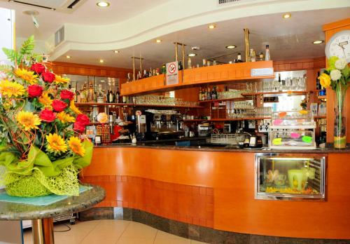 卡奥莱Albergo Santa Margherita的餐厅的酒吧,餐桌上有鲜花