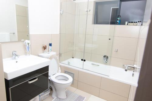鲁德普特Luxury 2 Bedroom Lifestyle Apartment in Golf Estate的浴室配有卫生间、盥洗盆和浴缸。