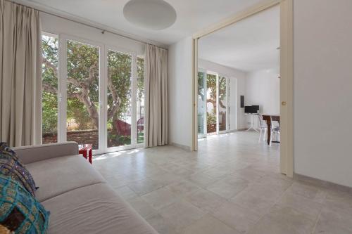 莱乌卡Villetta Federica by BarbarHouse的带沙发和大窗户的客厅