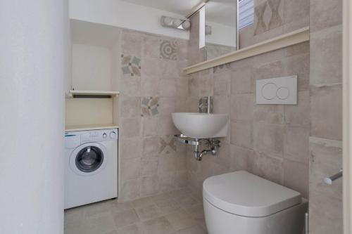 莱乌卡Villetta Federica by BarbarHouse的浴室配有卫生间、盥洗盆和洗衣机。