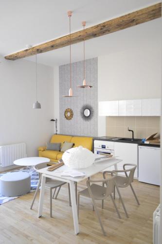 里昂Cosy apartment ideally located in the Old Town的厨房以及带白色桌椅的用餐室。