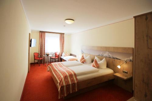 比绍夫斯维森布瑞奈巴斯彻特艾尔潘酒店的酒店客房带一张床、一张桌子和椅子