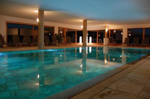 阿尔卑斯休斯山戈斯塔斯旗酒店的酒店的大型游泳池配有椅子