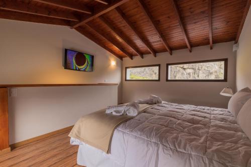 厄尔查尔坦Andino Aparts - El Chaltén的一间卧室设有一张大床和两个窗户。