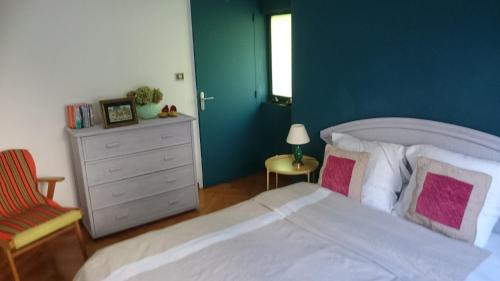 QuinsacLe Gîte的卧室配有白色的床和绿色的墙壁