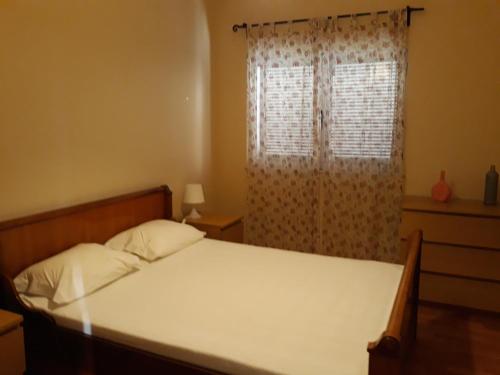 ArmaesApartamento Carvoeiro的一间卧室配有床和带窗帘的窗户