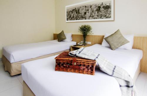 罗勇三颗星公寓式酒店的两张床铺位于一个房间,中间有桌子