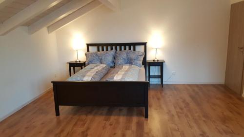 施皮茨施皮茨阿提卡公寓的一间卧室配有一张床,两台桌子上放着两盏灯