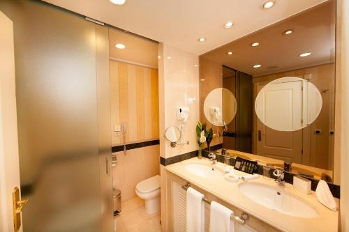 马贝拉古达平精品公寓酒店的浴室设有2个水槽、卫生间和镜子。