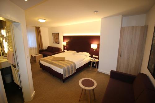 波恩阿德勒高级酒店的酒店客房带一张大床和一把椅子