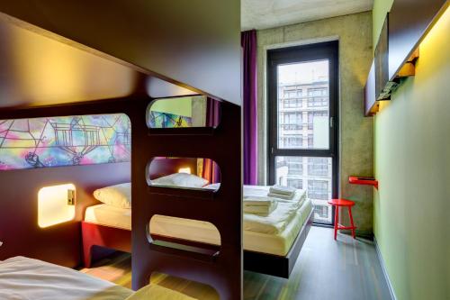 柏林柏林东边画廊梅宁阁酒店的一间卧室设有两张双层床和一扇窗户。