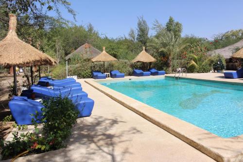 Ndangane莱斯科登斯布罗伊斯酒店的一个带蓝色椅子和遮阳伞的游泳池