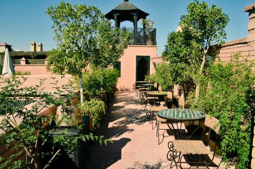 马拉喀什利雅得艾雷亚卡酒店的一个带桌椅的庭院和一个凉亭
