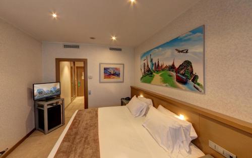帕特纳马斯卡马雷纳酒店的酒店客房设有一张床,墙上挂有绘画作品