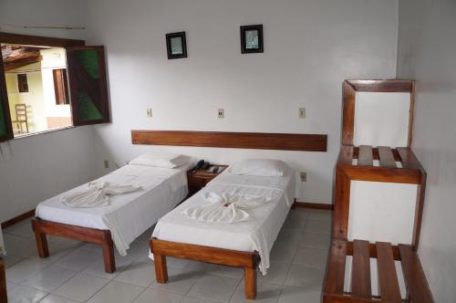 ItajuípePousada Do Bosque的带两张床和镜子的客房