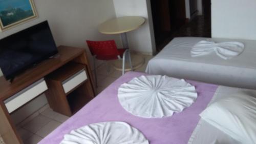 拉古纳Hotel Monte Líbano的小房间设有两张床、一张桌子和椅子