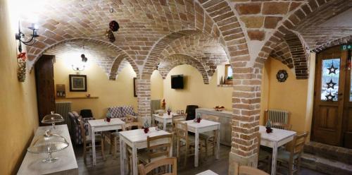 佩斯科克斯坦佐Donna Matilde的一间设有白色桌椅的餐厅,拥有砖墙