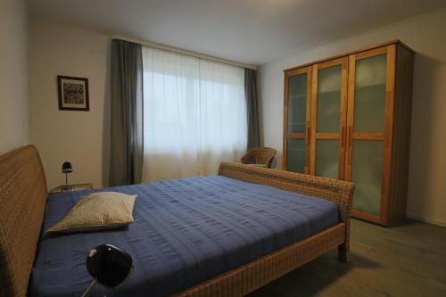 吕讷堡City-Apartment - Lüneburg Schwalbengasse的一间卧室配有一张带蓝色床单的床和窗户。