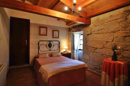 维拉波Casa do Americano的一间卧室设有一张床和石墙