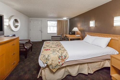 弗林特Knights Inn Flint的酒店客房设有一张大床和一张书桌。
