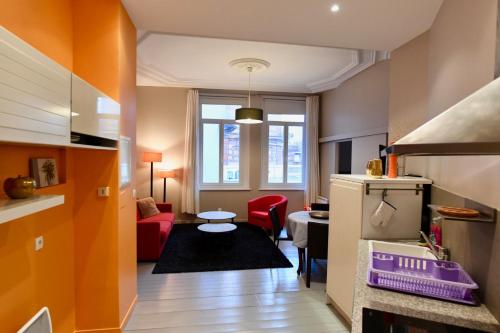敦刻尔克Appartement Week-end的一间厨房和一间带红色沙发的客厅