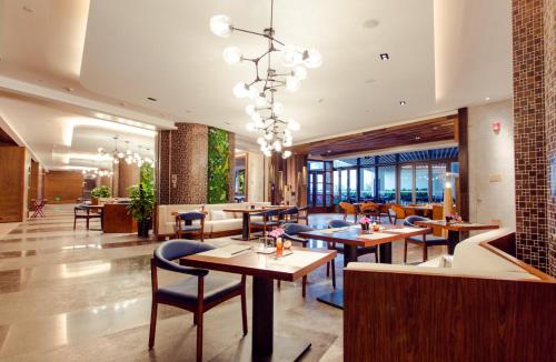 三亚三亚康年酒店的一间带桌椅和吊灯的餐厅