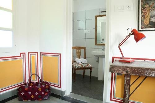 乌代浦小花园宾馆的走廊上设有浴室,备有行李袋