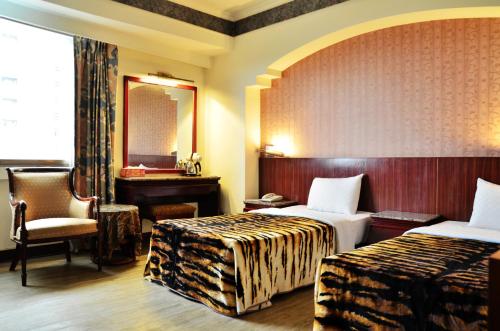 台南哥爸妻夫商务饭店-林森馆 的酒店客房,设有两张床和镜子