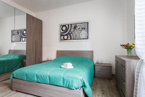博洛尼亚Il Filo di Arianna的一间卧室配有绿色的床和梳妆台