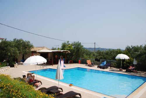 Agia Marina阿纳托利拉布莱昂酒店的旁边设有一座带椅子和遮阳伞的大型游泳池