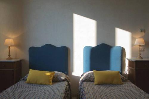 格罗塔列Masseria Rosario的配有两张蓝色椅子的房间内的两张床