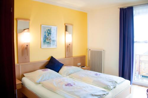 沃尔夫斯堡Gasthof Pension Zoller的一间卧室配有带2个枕头的床