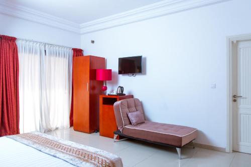达喀尔Le Feto 3的一间卧室配有椅子和电视
