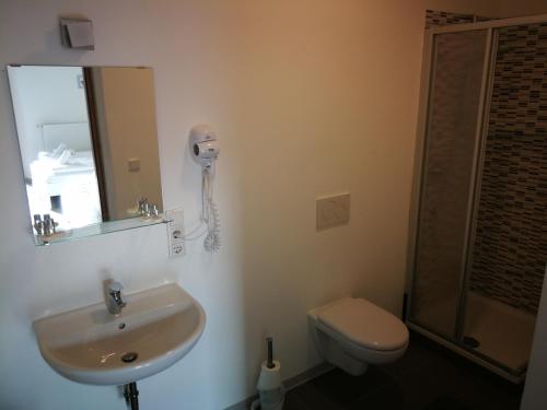 博尔扎诺Iceman Room's Central的一间带水槽和卫生间的浴室以及一部电话
