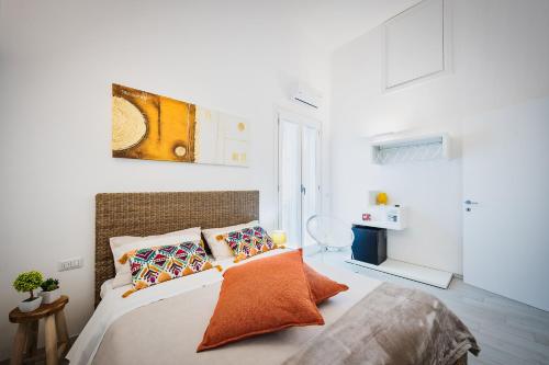 莱切La casa di Giovanni的白色卧室配有带橙色枕头的床