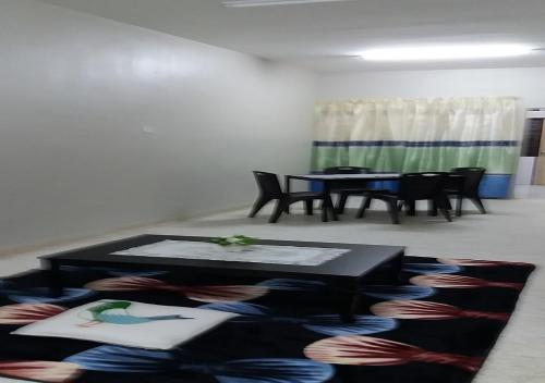 马六甲巴图贝伦丹度假屋的客厅配有桌椅和地毯。