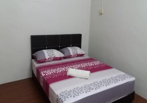 马六甲巴图贝伦丹度假屋的一张带粉色和白色床单及枕头的床