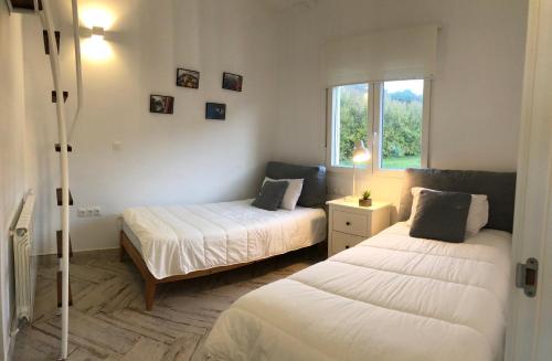 圣马尔塔奥尔蒂盖拉Celtigos Beach Resort的一间卧室设有两张床和窗户。