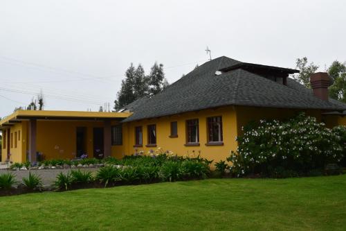 卡扬贝Casa de Campo的前面有草坪的黄色房子