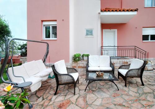 帕拉利亚维拉乔Villa Sunset的一个带桌椅的庭院和一座建筑